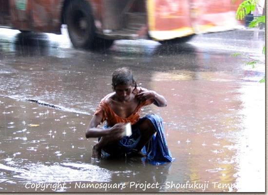 コルカタで。雨水を気持ちよさそうに浴びながら身体を洗う老婆。
